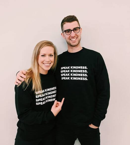 Two people posing in “Speak Kindness” t-shirts.